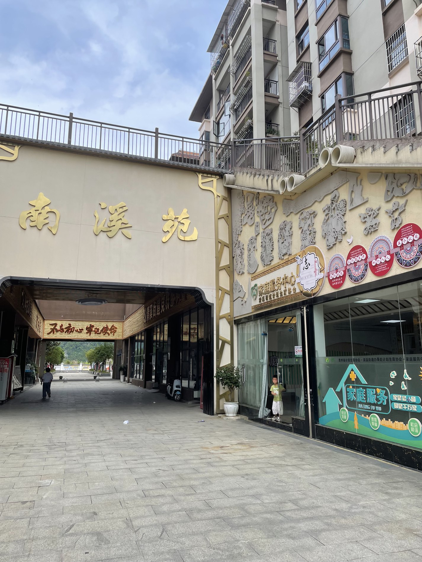 Entrance to the Nanxiyuan resettlement community, storefronts along the street