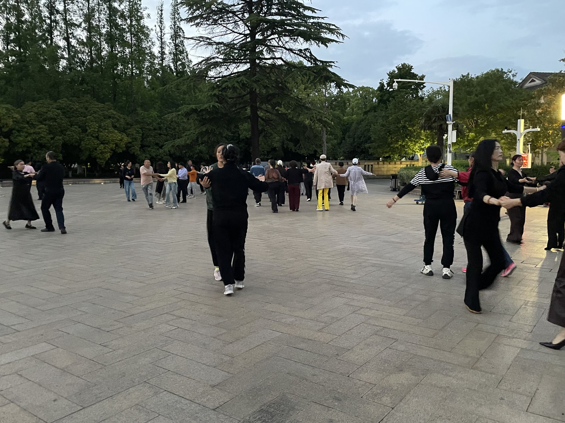 Women square dancing in a park in the evening