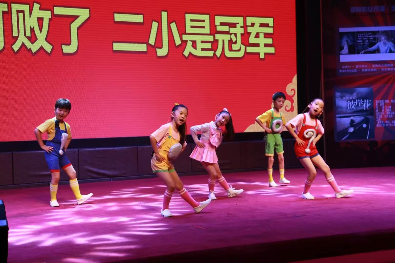 Children in colourful costumes on stage during the finals