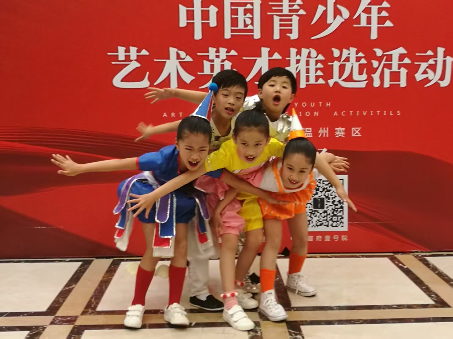 Children in colourful costumes performing on stage