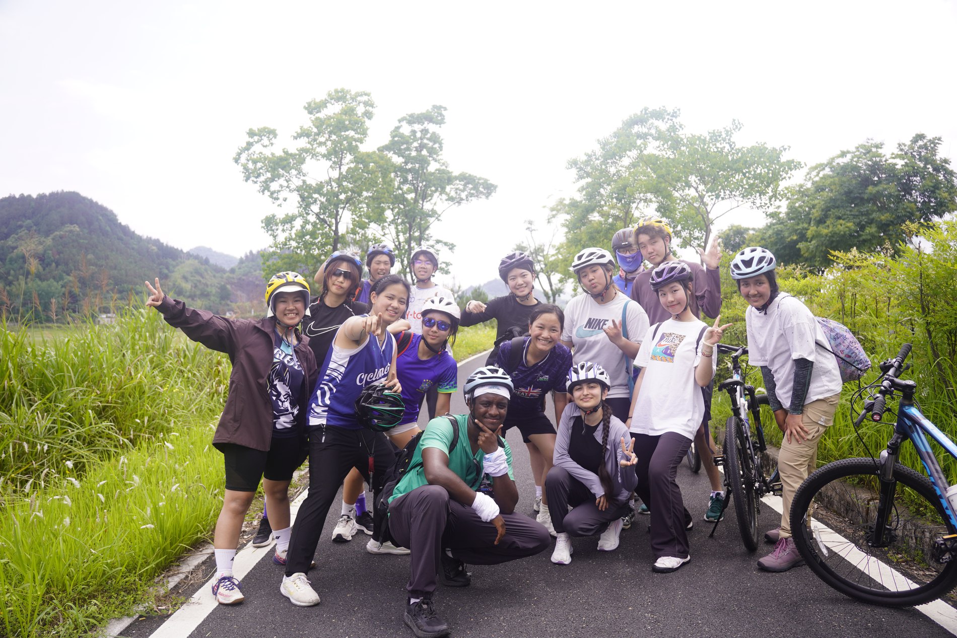 Group cycling trip, posing beside bicycles on a trail