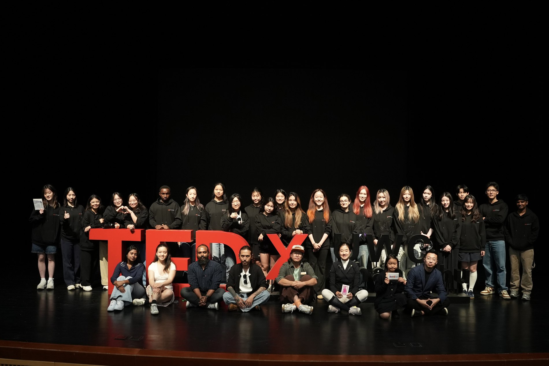 Full production crew on stage behind the TEDx letters after the event