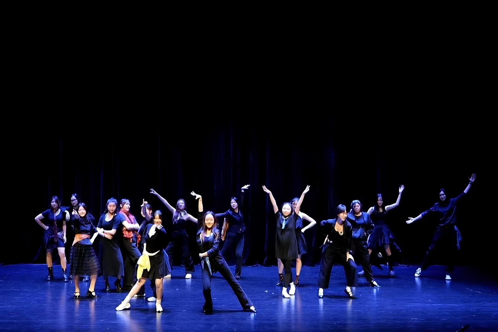Dance ensemble under blue stage lighting