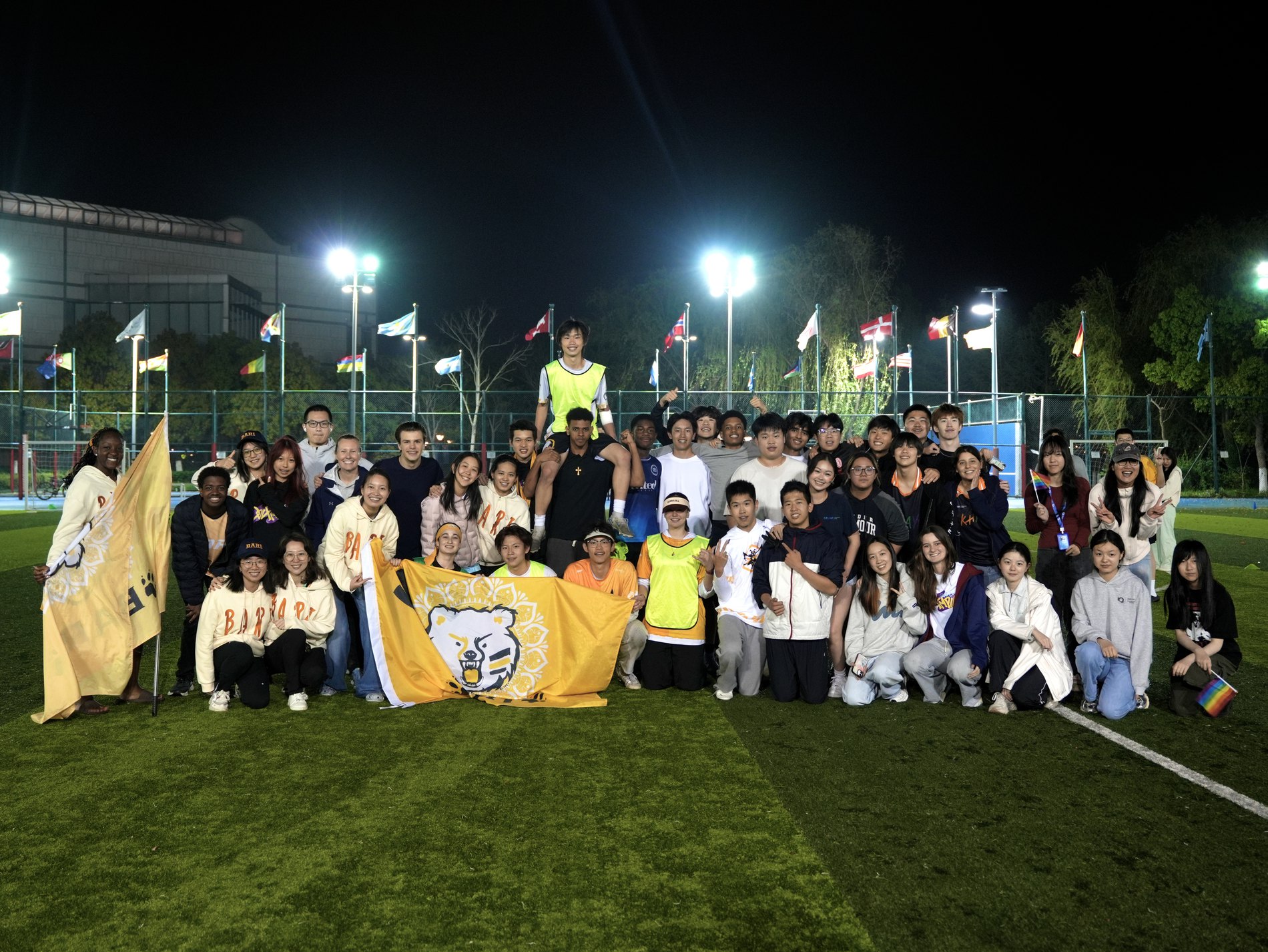 Large group photo on a school field at night