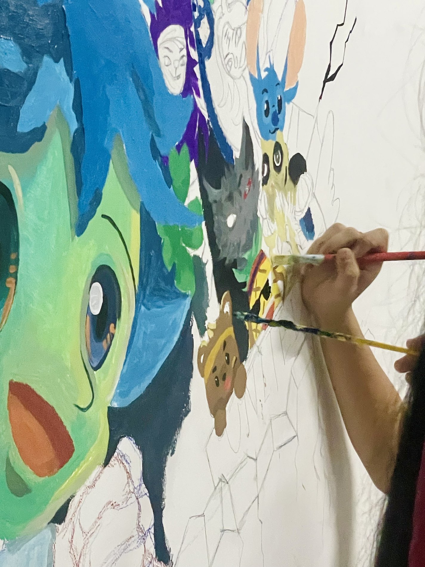 Painting a large colorful mural of cartoon animal characters