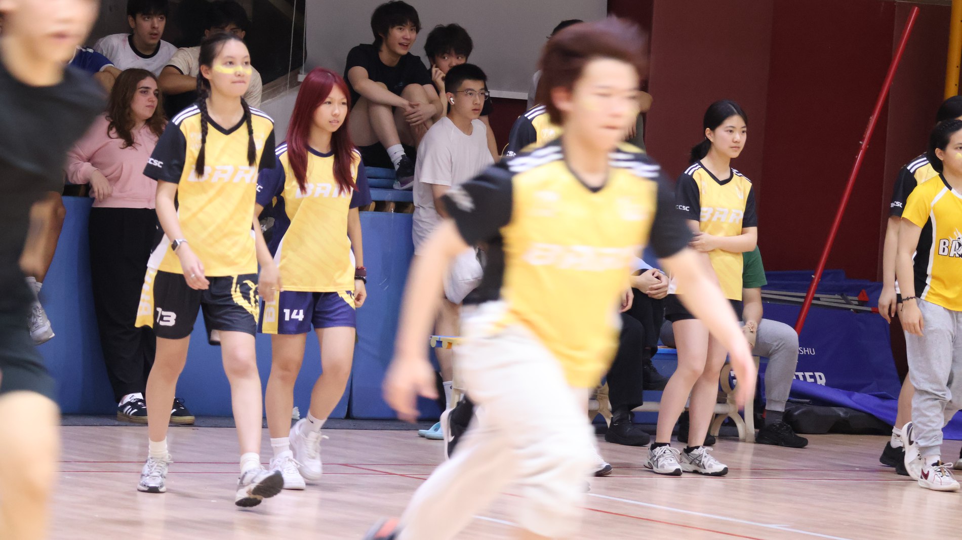 Playing in a school basketball match, teammates in yellow jerseys
