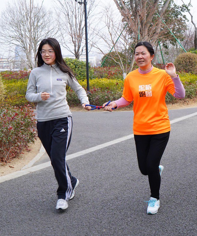 Two guide runners jogging together on a road